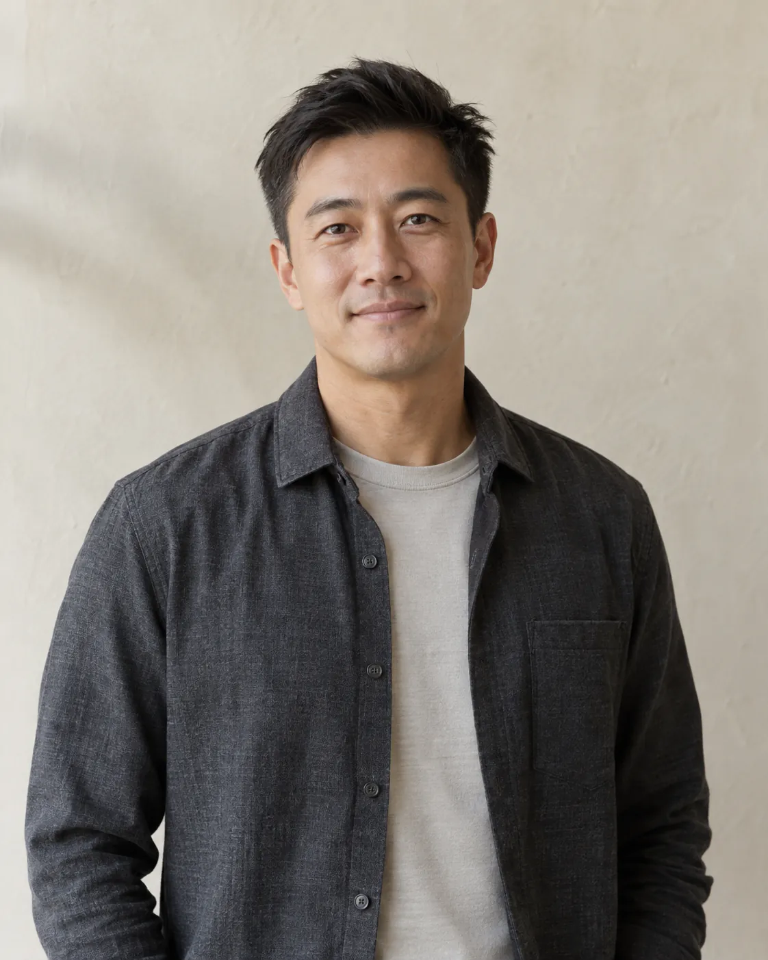 AI-generated placeholder portrait of a fictional team member wearing a charcoal overshirt.