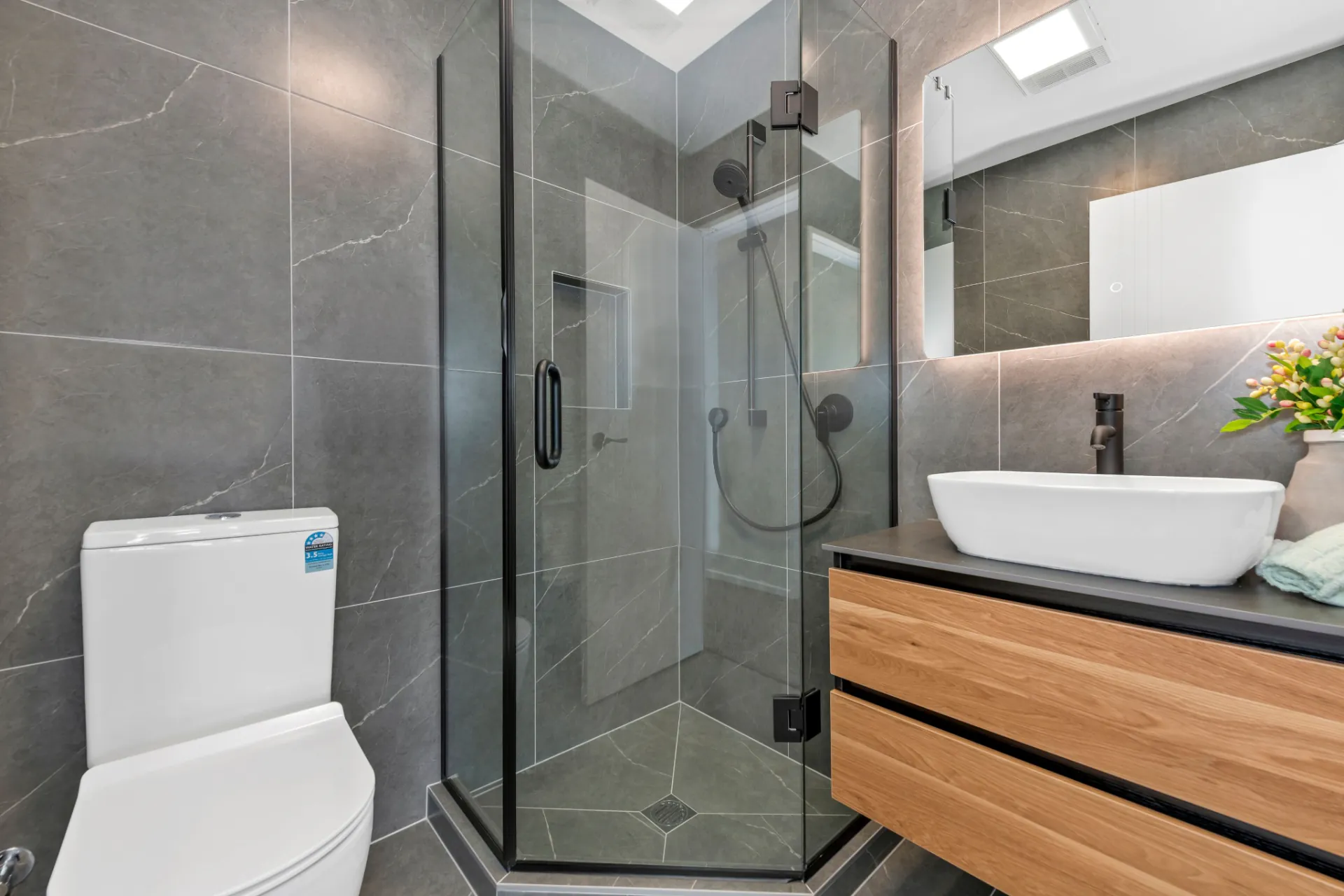 Original Botany Downs bathroom photograph showing the toilet on the left, the complete glass shower in the centre and the timber vanity on the right.