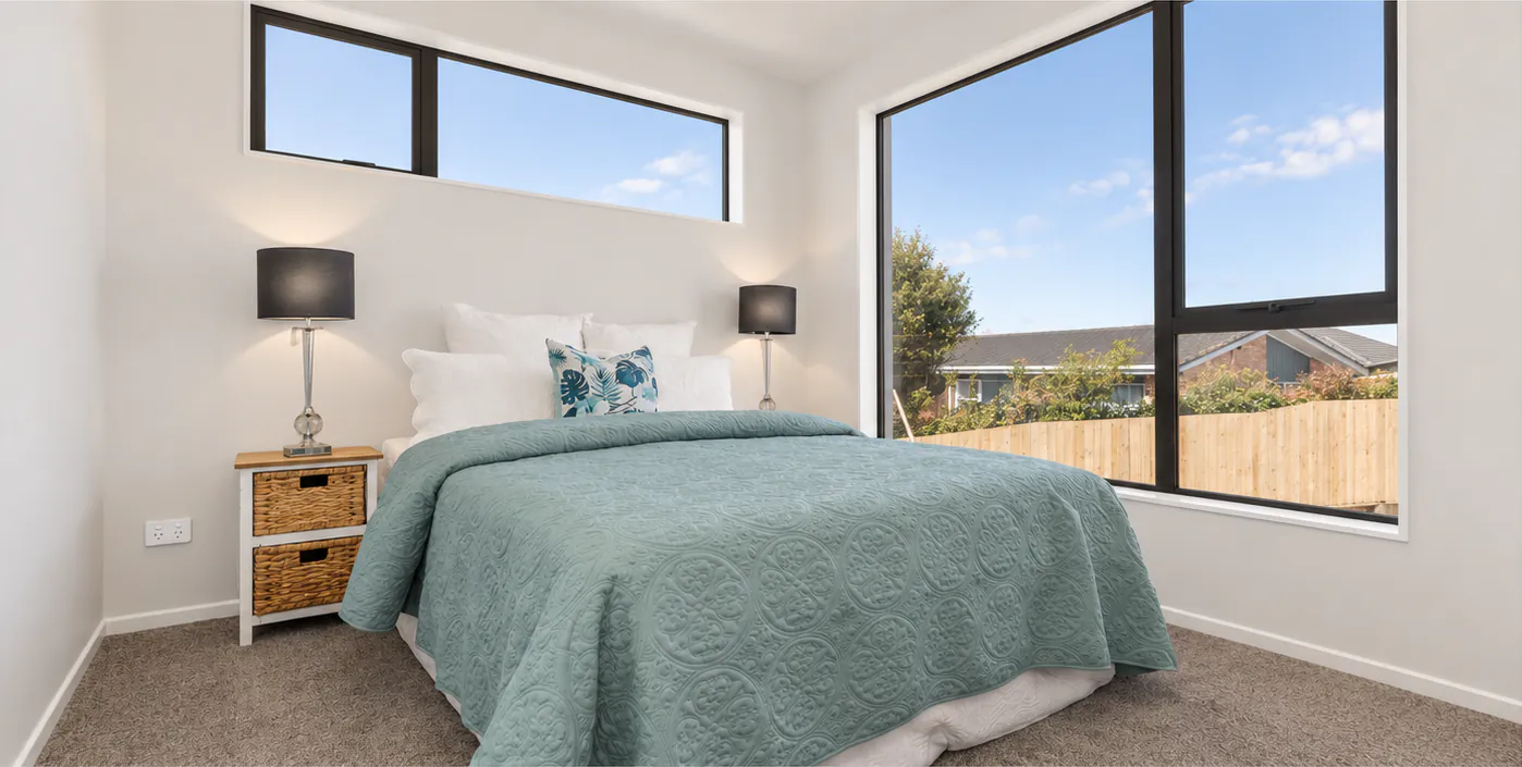 AI-retouched project photograph: a Botany Downs bedroom with a teal bedspread and two large black-framed windows.
