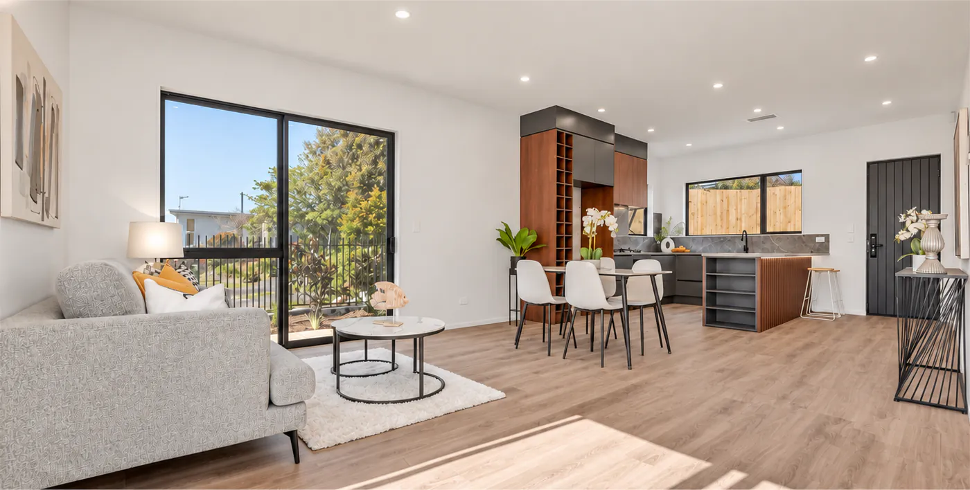 AI-retouched project photograph: the Botany Downs living and dining room, with timber flooring and the kitchen beyond.